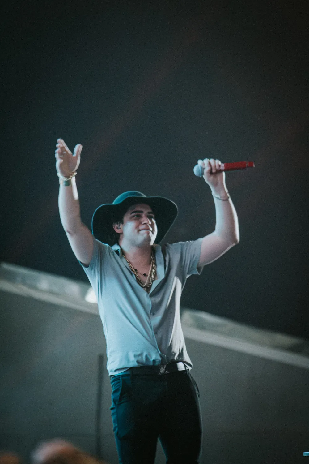 Natanzinho de chapéu com os braços erguidos no palco — Rodeio Fest 2026, 08.08