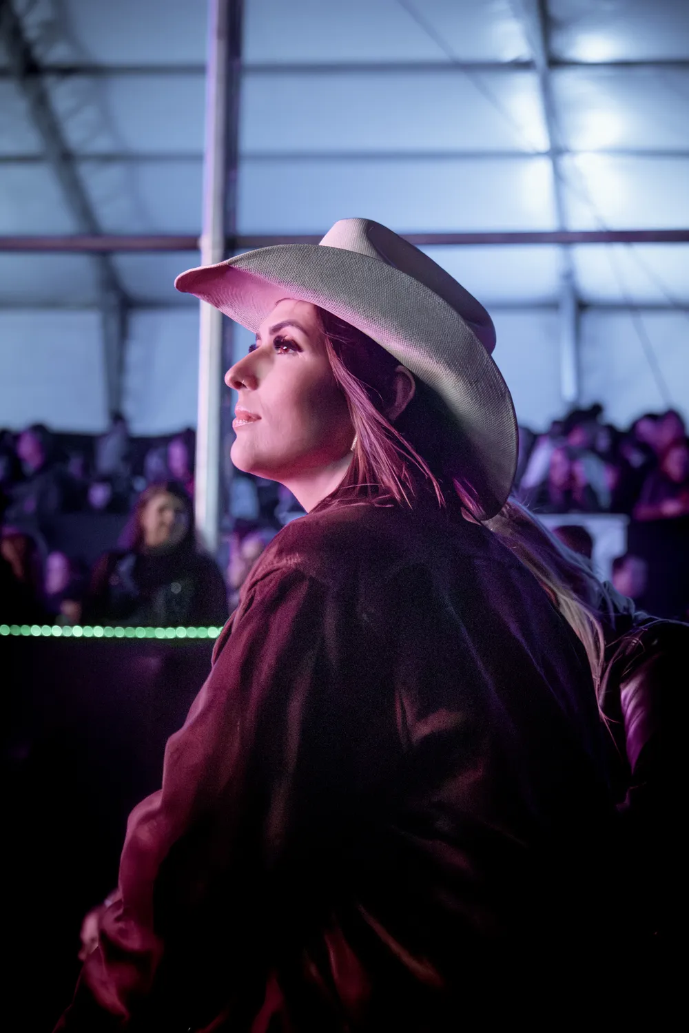 Mulher de chapéu olhando para o palco — Rodeio Fest 2026, 07.08