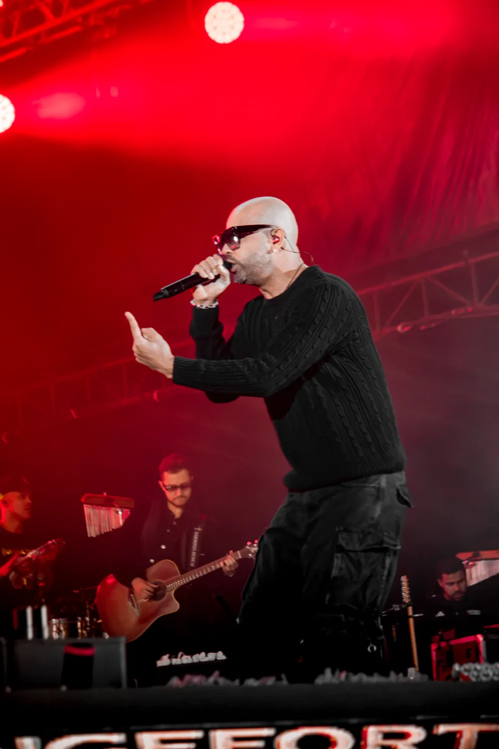 Cantor ao microfone sob luz vermelha — Rodeio Fest 2026, 07.08